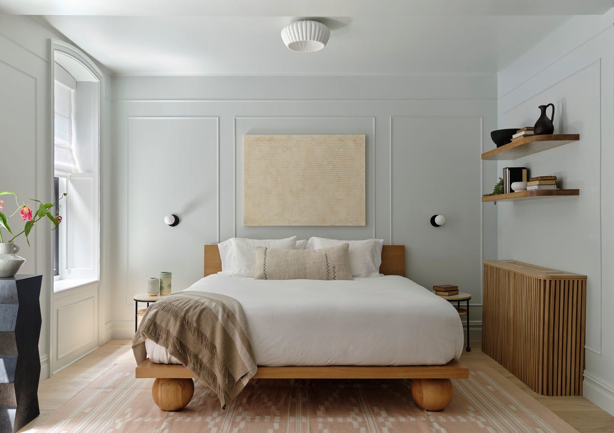 Scandinavian bedroom by the Brownstone Boys with gray-green walls and pale wood bed. Photo: House Beautiful