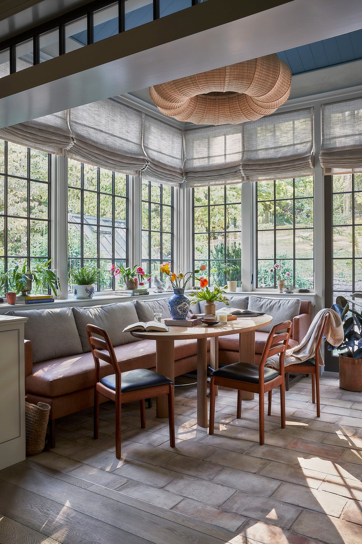Biophilic sunroom with tall windows and potted greenery. Photo: House Beautiful