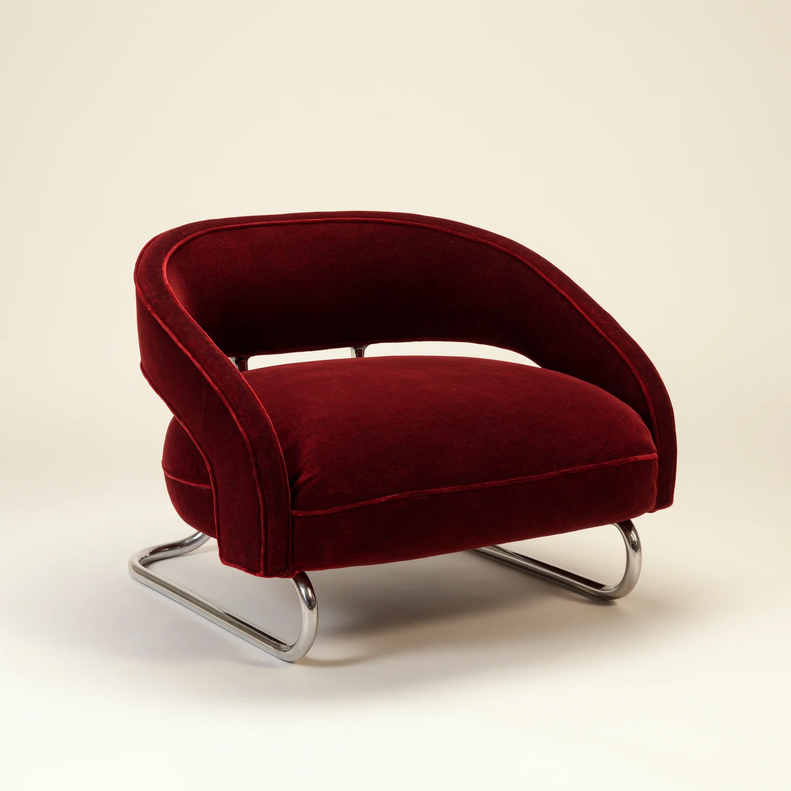 Oxblood velvet lounge chair on a chrome sled base