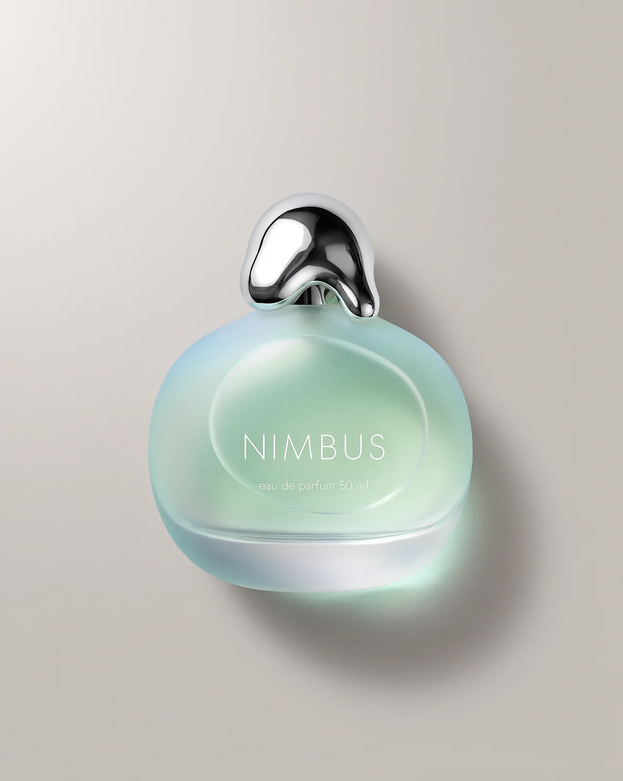 Frosted seafoam perfume bottle on a grey studio background
