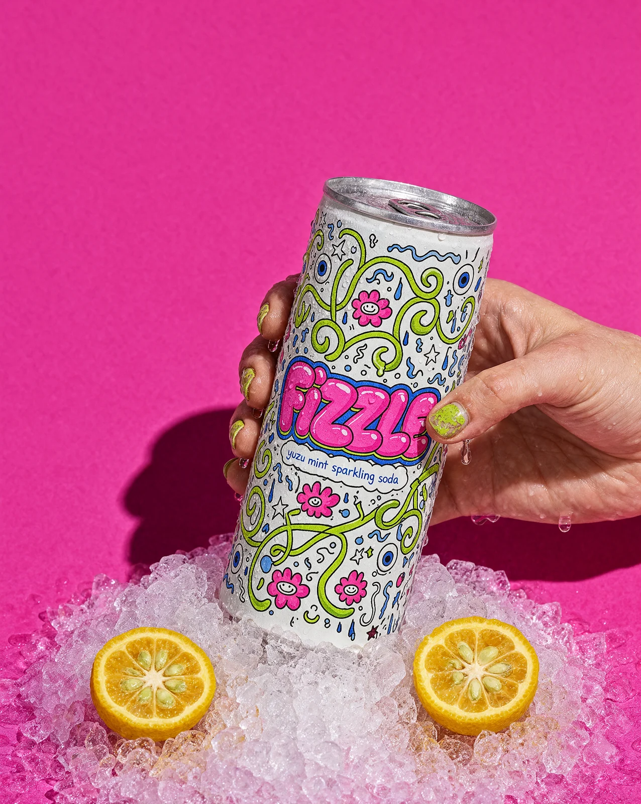 The same can in a hand, pushed into crushed ice with halved yuzu