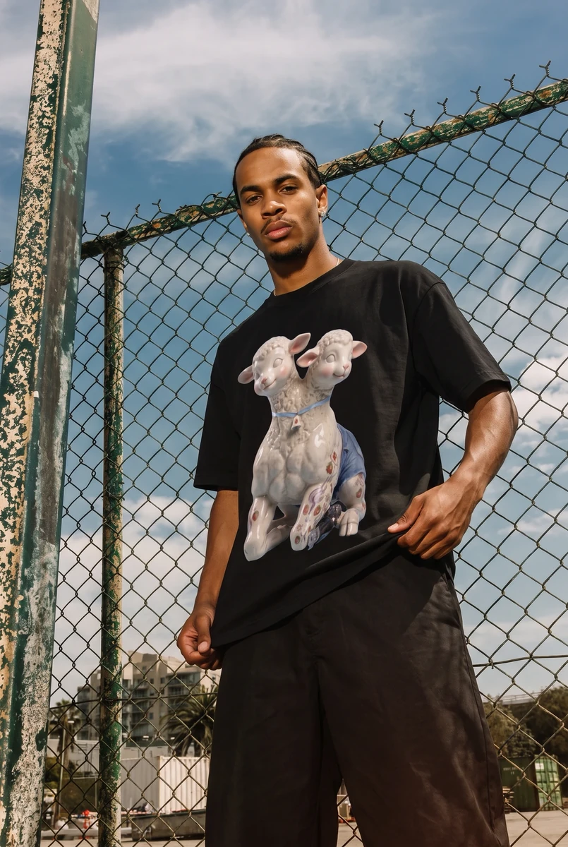 Streetwear portrait beside a chain-link fence